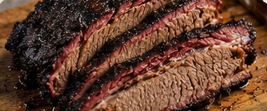 Sliced smoked brisket showing a dark bark and pink smoke ring